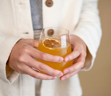 Una persona sostiene un vaso de kombucha. Se ve saludable.