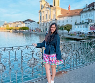 a woman standing on a bridge over looking at the water