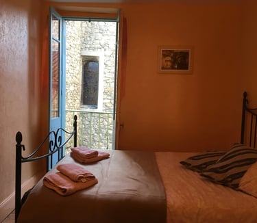 Double bedroom with balcony and church view in Quillan