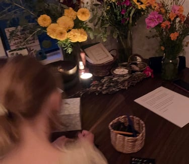 A young girl writing at a table with a home funeral altar.