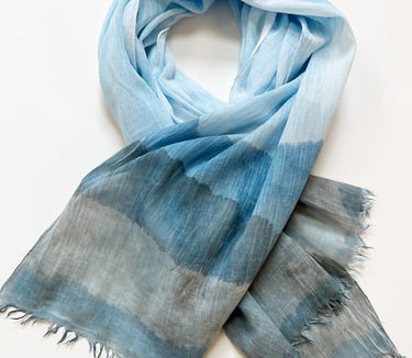 Light blue and gray oblong scarf with a soft watercolor gradient pattern and frayed edges.