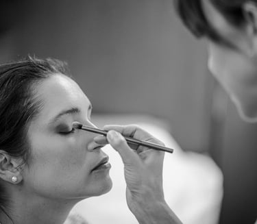 The bride getting her makeup done before the wedding