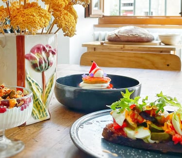 a table with a vase of flowers and brunch with plates
