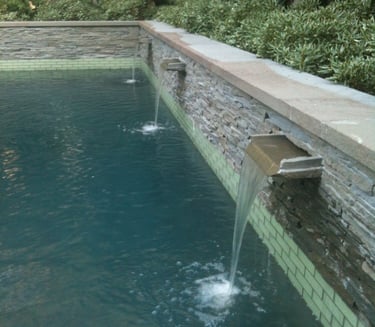 a pool with three custom stone spillways