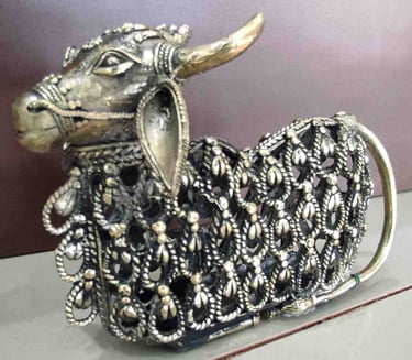 Decorative brass figurine of a sitting bull featuring intricate tribal cutwork design