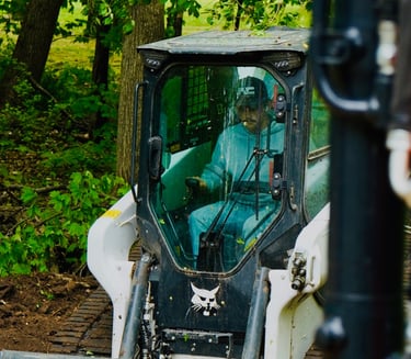 Owner, Patrick Kruse, in a bobcat skid steer grading dirt