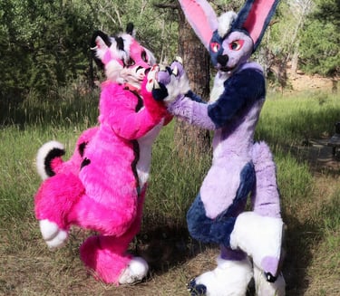 two furry fursuits standing with hands pressed togeather
