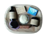 a grouping of skincare products on a wooden tray