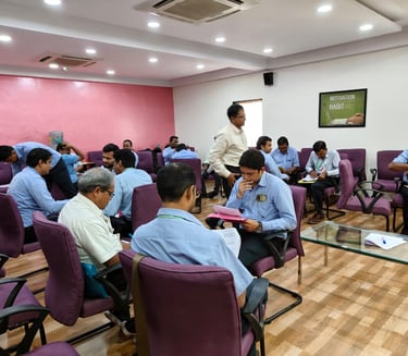 a man in a white shirt is standing in front of a room full of people
