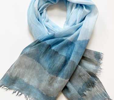 Light blue and gray oblong scarf with a soft watercolor gradient pattern and frayed edges.