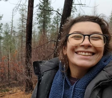 A smiling person in a forest