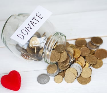 Donation jar filled with coins for supporting Auckland International Film Club events.