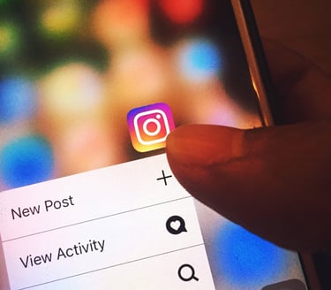 Hand selecting a new Instagram post to follow Auckland International Film Club on social media.