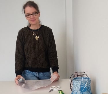a woman sitting at a table with a paper bag