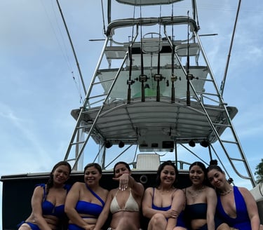 a group of women in bikinis sitting on a boat