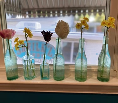 a row of glass bottles with flowers in them