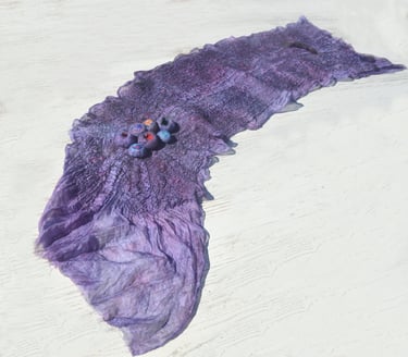 Handmade purple nuno felted silk scarf with decorative wool 3D elements on a white surface.