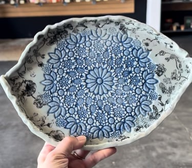 an eye shaped plate with a lace texture in blues and pale blue glaze