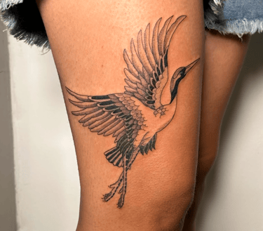 a japanese style tattoo of a crane bird on the thigh of a woman's thigh