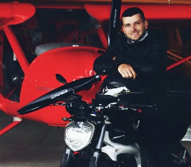 Audrius Turskas a cool man sitting on a motorcycle in a garage next to airplane 