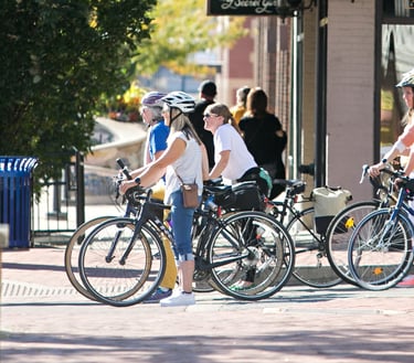 4 women on bikes stopped at a stop light