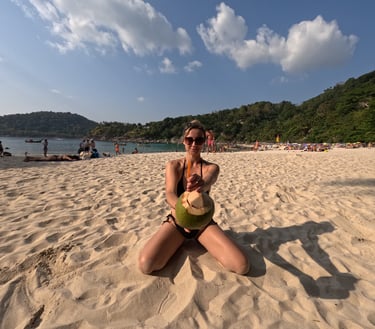 kobieta w bikini z kokosem na plaży w Tajlandii