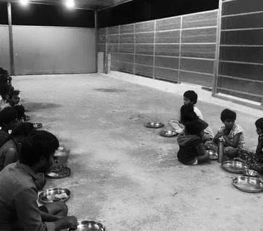 a group of people sitting on the ground eating food food green Way Association