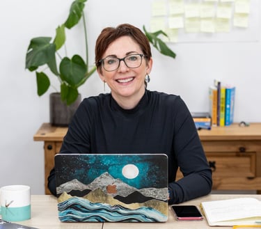 a woman sitting at a desk with a laptop computer