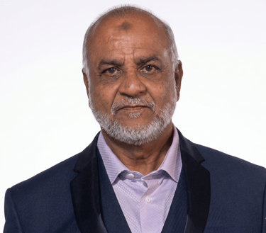 Professional headshot of a senior man with a grey beard wearing a navy blue suit jacket.