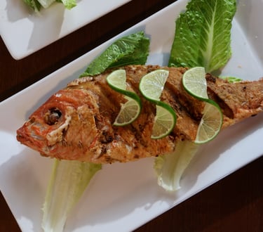 a plate of fried fish trout garnish with lemon slices