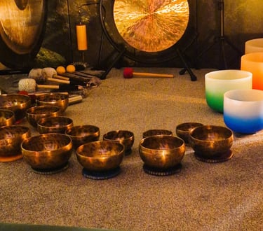 Studio with gongs and singing bowls on the floor in front of two pillows