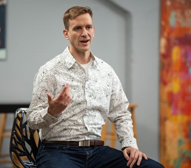 Remy sits gesturing during a small group talk