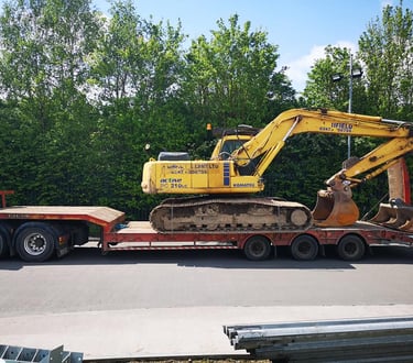 yellow digger loaded on the back of a van in dudley