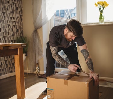 dean from deanos removals taping up a box in a worcestershire home