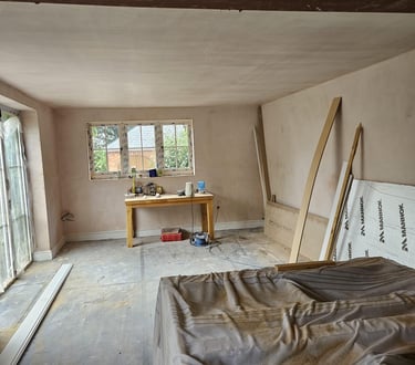 AN EMPTY ROOM THAT HAS BEEN PLASTERED AND A WINDOW