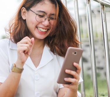 a woman sitting on a stair case holding a cell phone