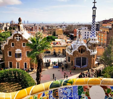 Panoramic view of Park Güell in Barcelona with Gaudi's colourful mosaic gatehouses.