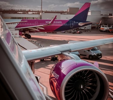 Two Wizz Air aircraft parked on the airport apron beside the terminal