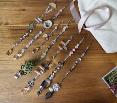 Handmade elegant crystal beaded suncatchers with glass prisms displayed on a wooden surface.