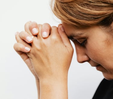 a woman holding her hands together in prayer