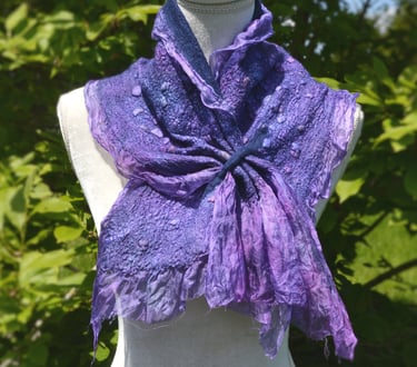 Handmade purple nuno felted wool scarf with textured ruffles displayed on a mannequin outdoors.