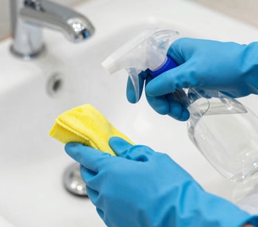 A person wearing blue gloves cleaning a sink in a home in Gainesville, Georgia.