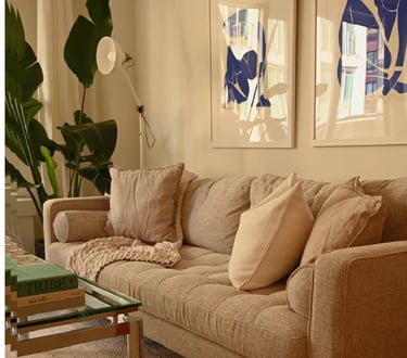 Cozy inviting living room with cream upholstery, warm lighting, and soft furnishings