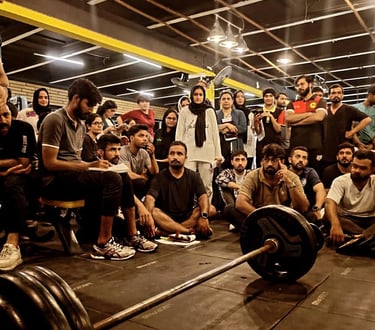 A diverse group of athletes attending a fitness seminar and barbell training workshop in a gym setting.