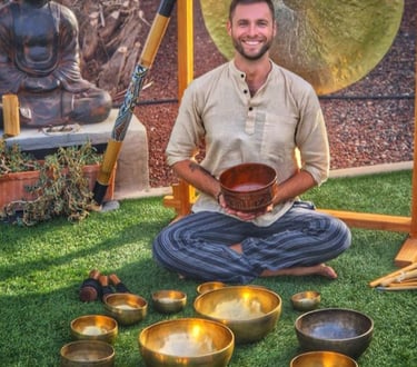 csaba seated in the middle of all sound therapy  instruments