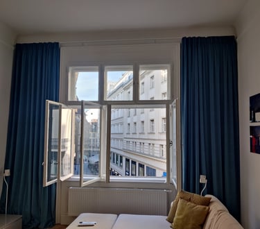 View of Vienna side street through window with velvet curtains