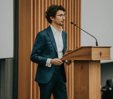 un giovane uomo che parla con un microfono davanti a un leggio