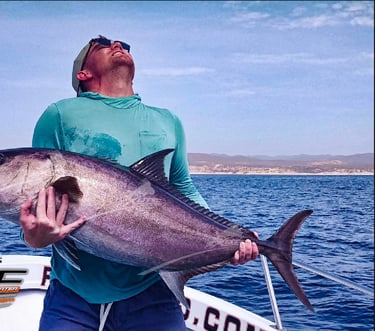 a man holding a fish on a boat