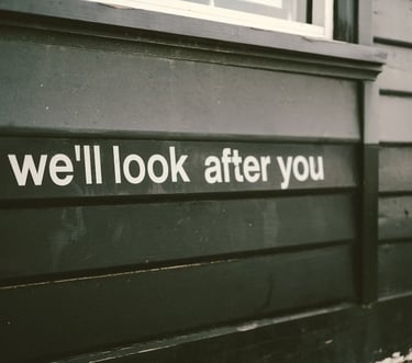 Unas letras pintadas en el costado de un edificio "we'll look after you"