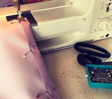 a piece of pink faux suede pinned on a sewing machine ready to be made into a cushion back